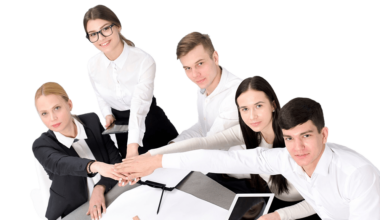 group-business-people-stacking-each-other-s-hand-desk-min group-business-people-stacking-each-other-s-hand-desk-min